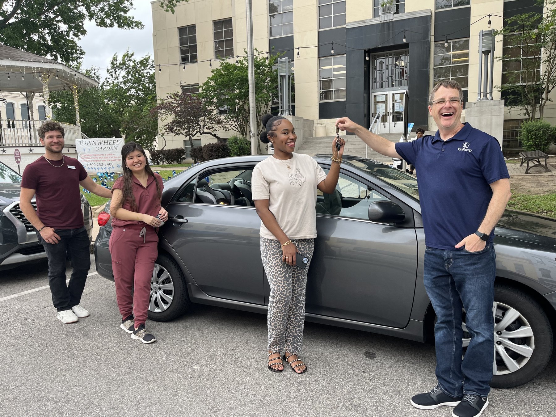 Blake handing a client the keys to her newly gifted vehicle outside the county courthouse