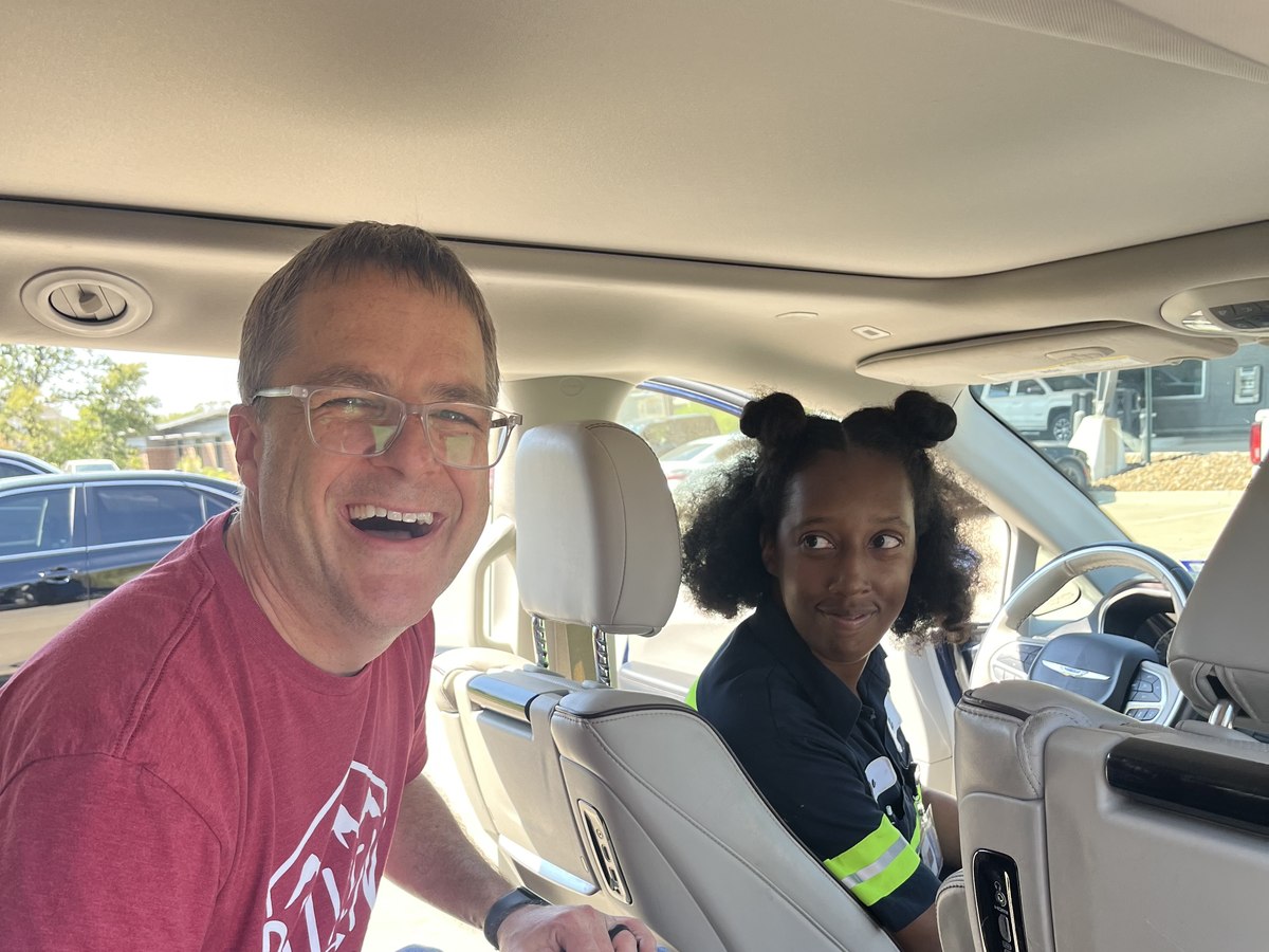 Blake laughing with an OnRamp client in the driver's seat of her new vehicle